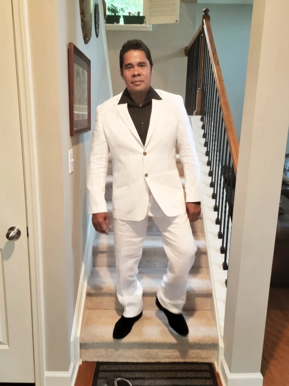 Peter in a white suit on a staircase