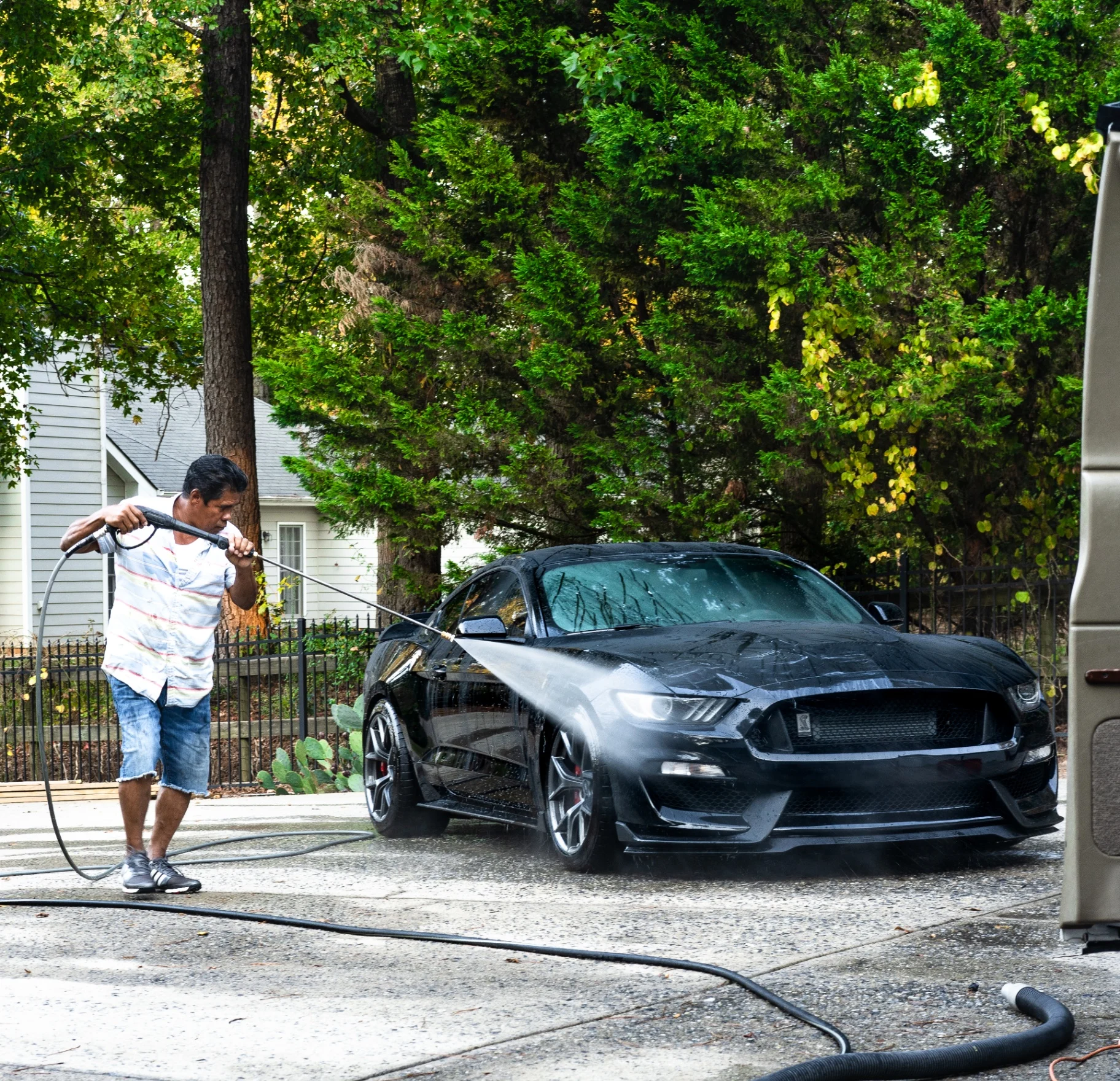 Peter hand-washing a car in a driveway